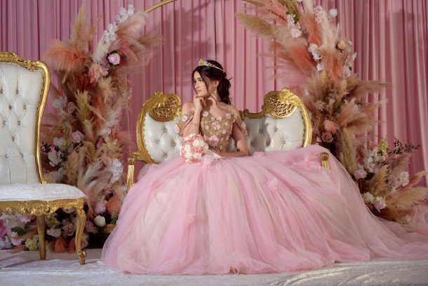 Quinceañera con vestido rosa posando en un parque de Chicago